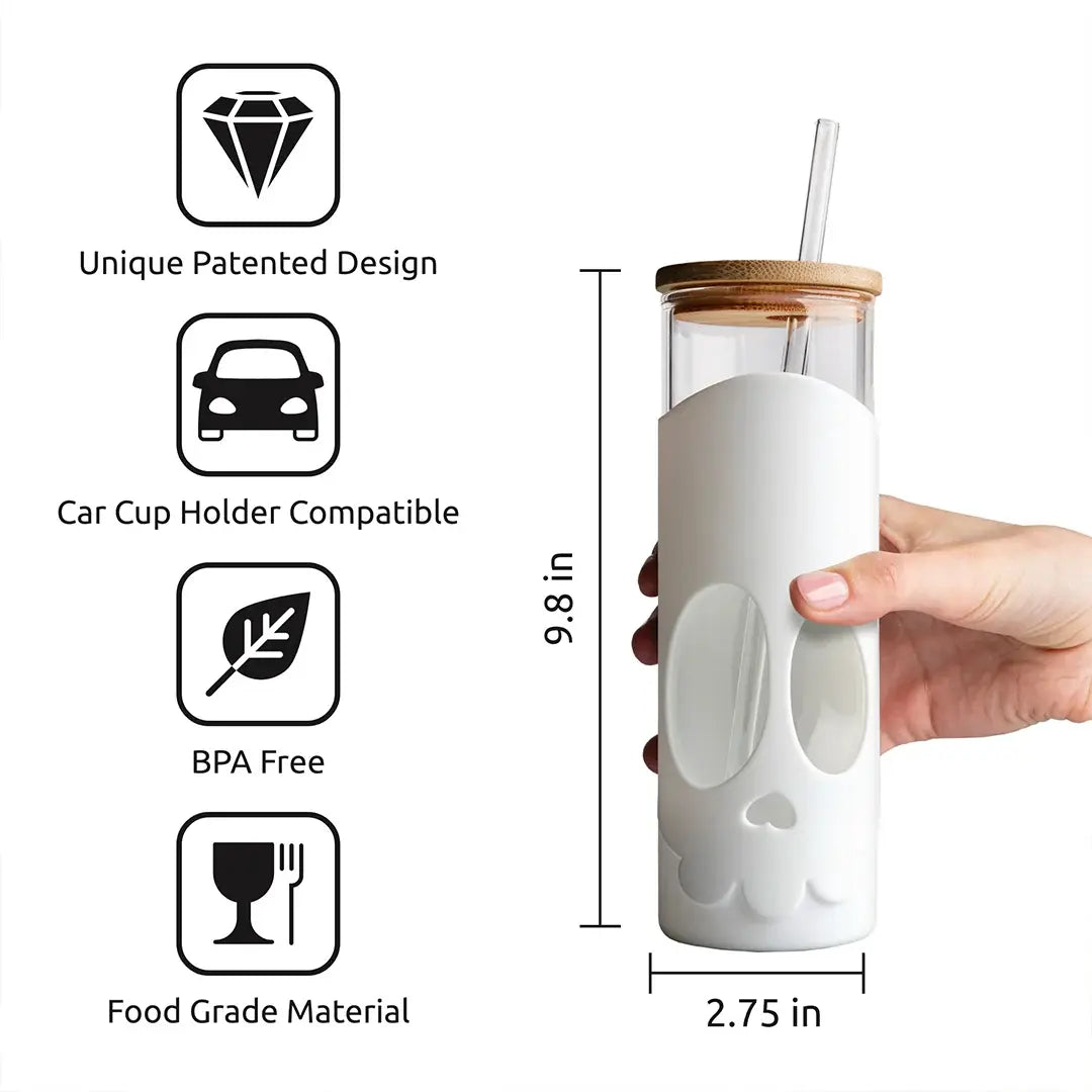a hand holding a glass bottle with a straw