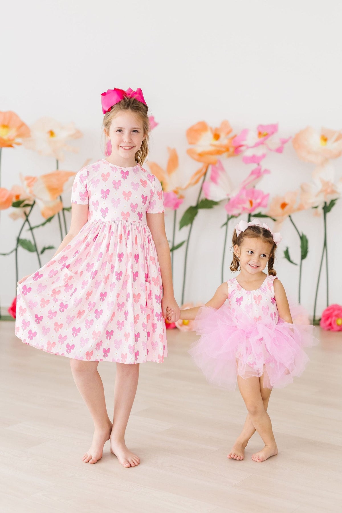 two girls holding hands and posing for the camera