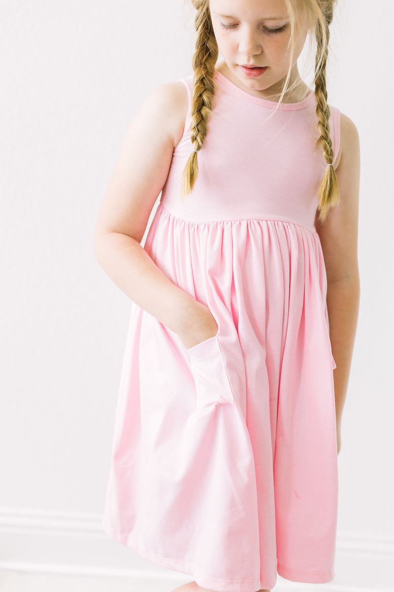 a girl with pigtails in a pink dress