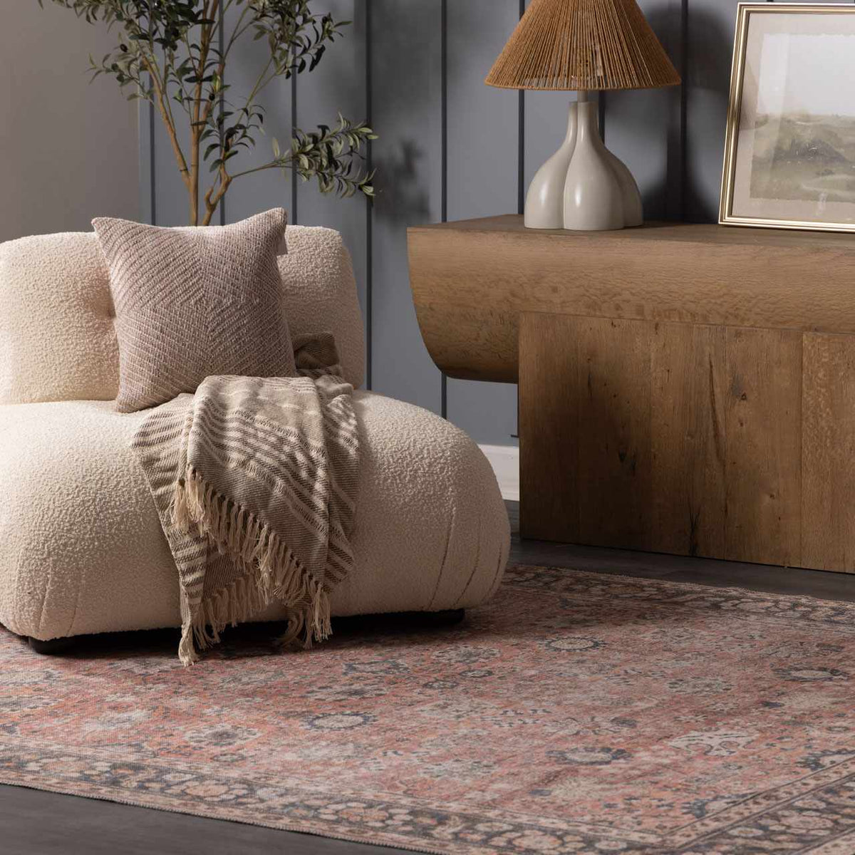 a chair with a blanket and a lamp on a rug