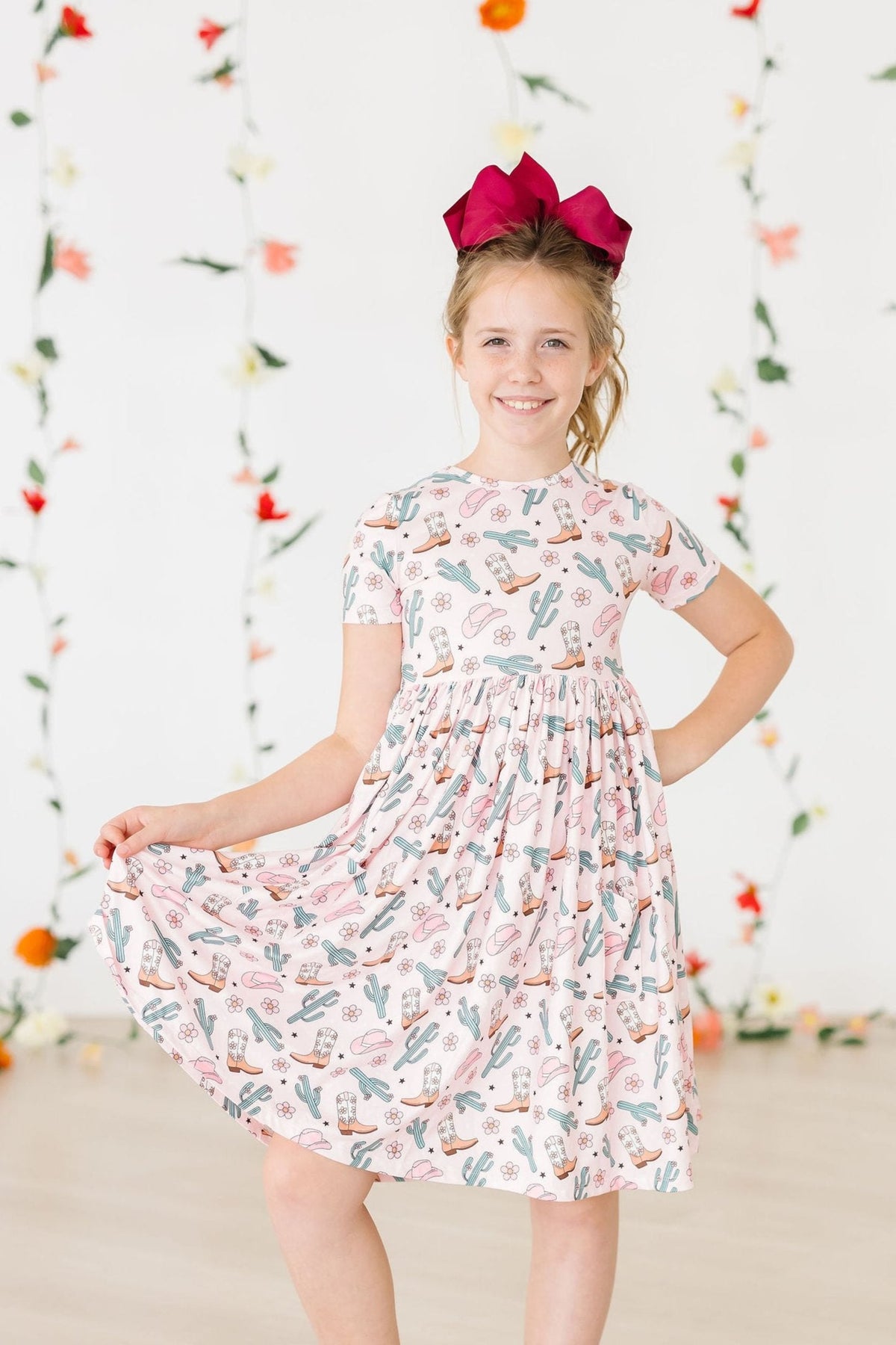a girl in a dress with a red bow