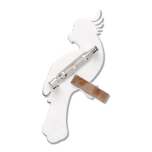 a white brooch with a metal bar and a bird