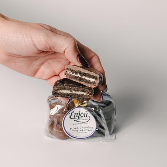a hand holding a chocolate sandwich