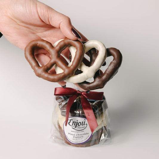 a hand holding chocolate covered pretzels