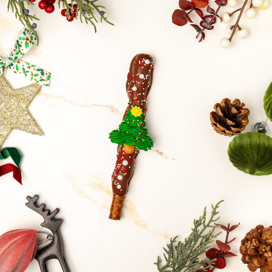 a chocolate covered candy cane surrounded by decorations