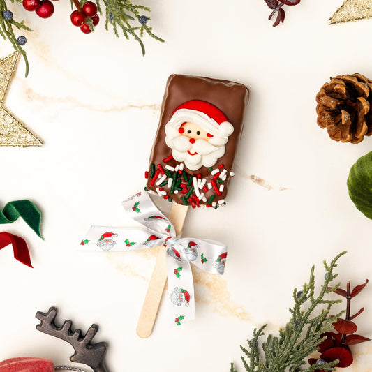 a chocolate covered ice cream bar with a bow surrounded by decorations