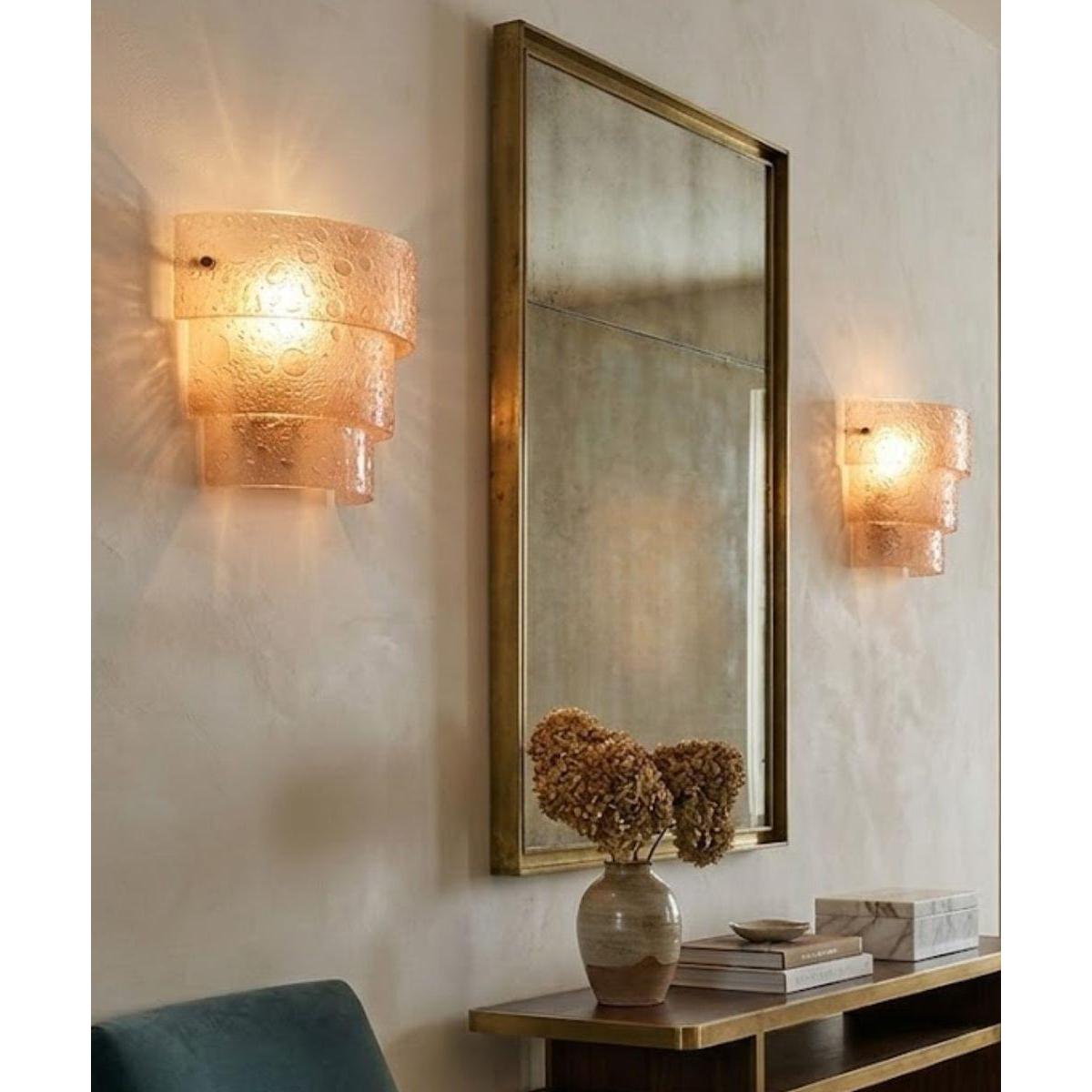 a mirror and sconce on a wall