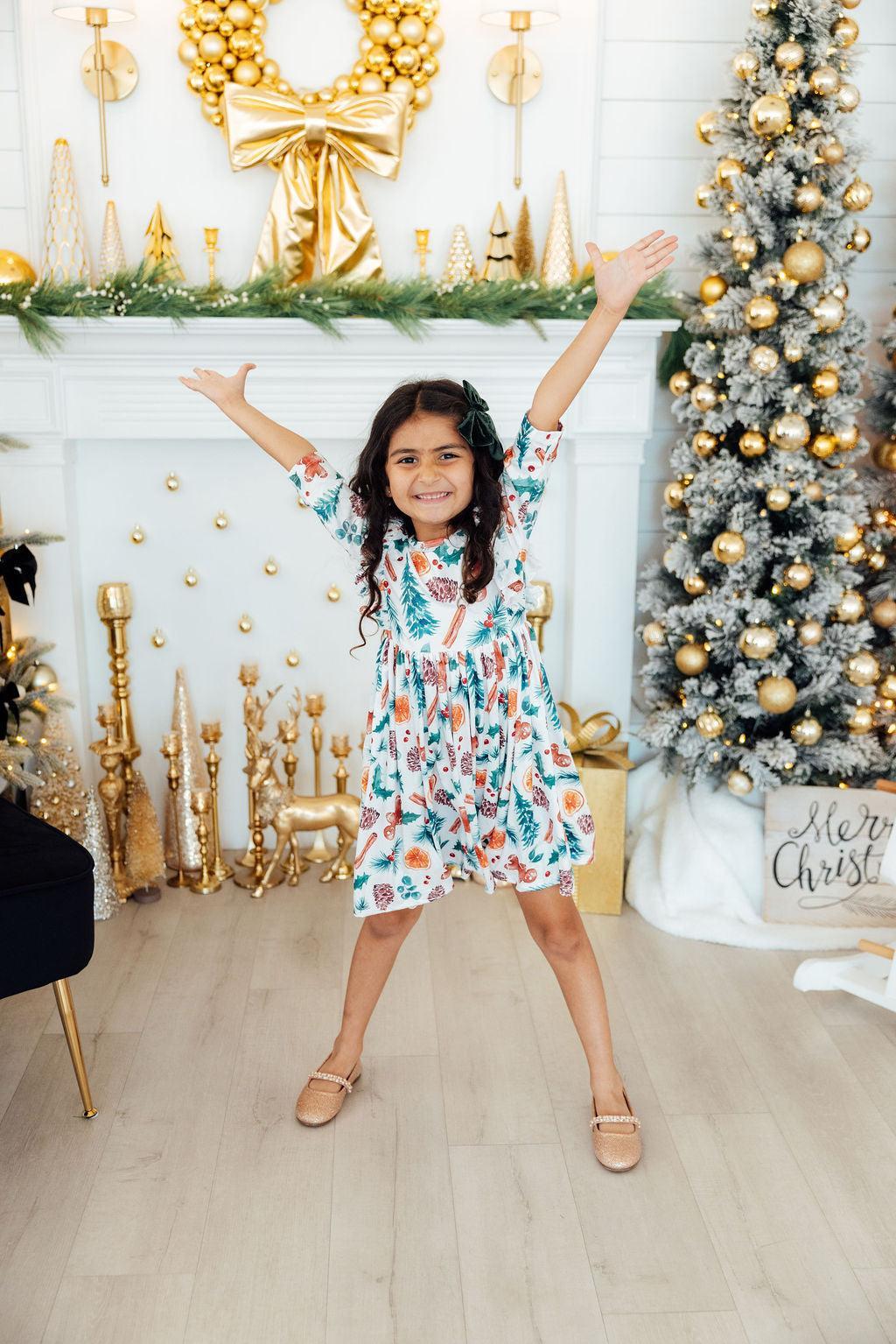 a girl posing for a picture in front of a christmas tree