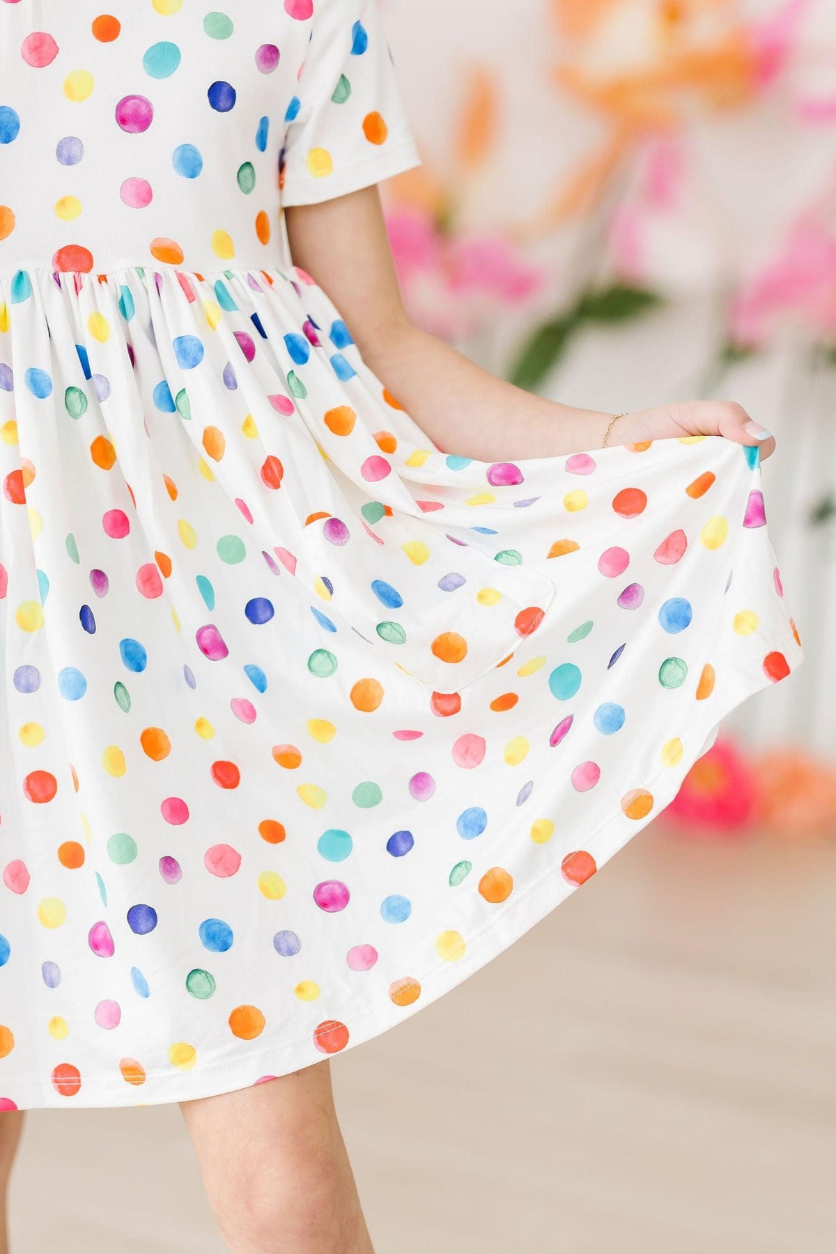 a girl wearing a dress with colorful polka dots