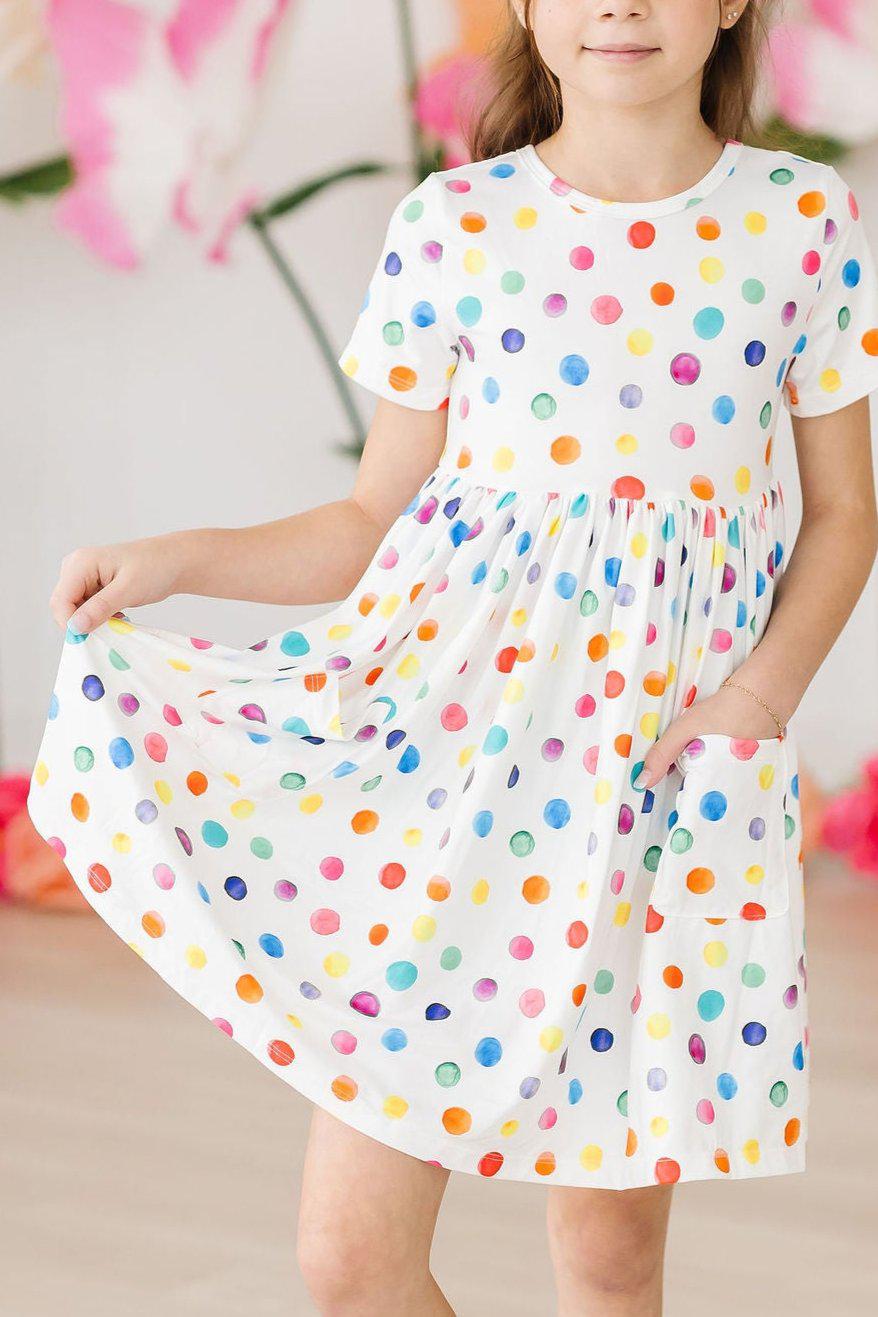 a woman wearing a dress with colorful polka dots