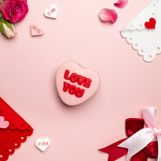 a pink heart with red text and envelopes and roses