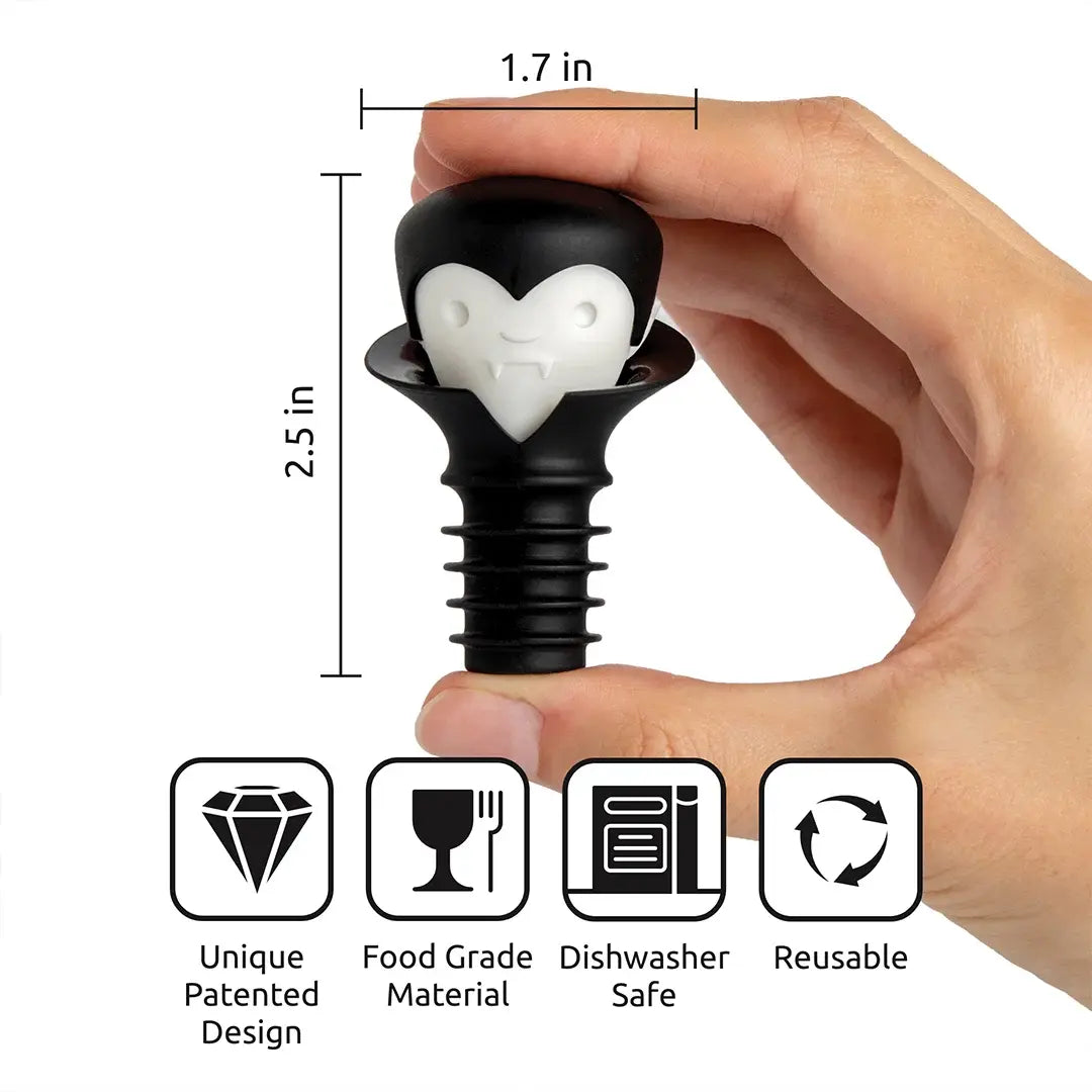 a hand holding a black and white penguin shaped bottle stopper