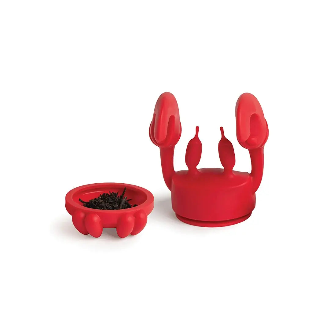 a red crab shaped object with a bowl of black dirt