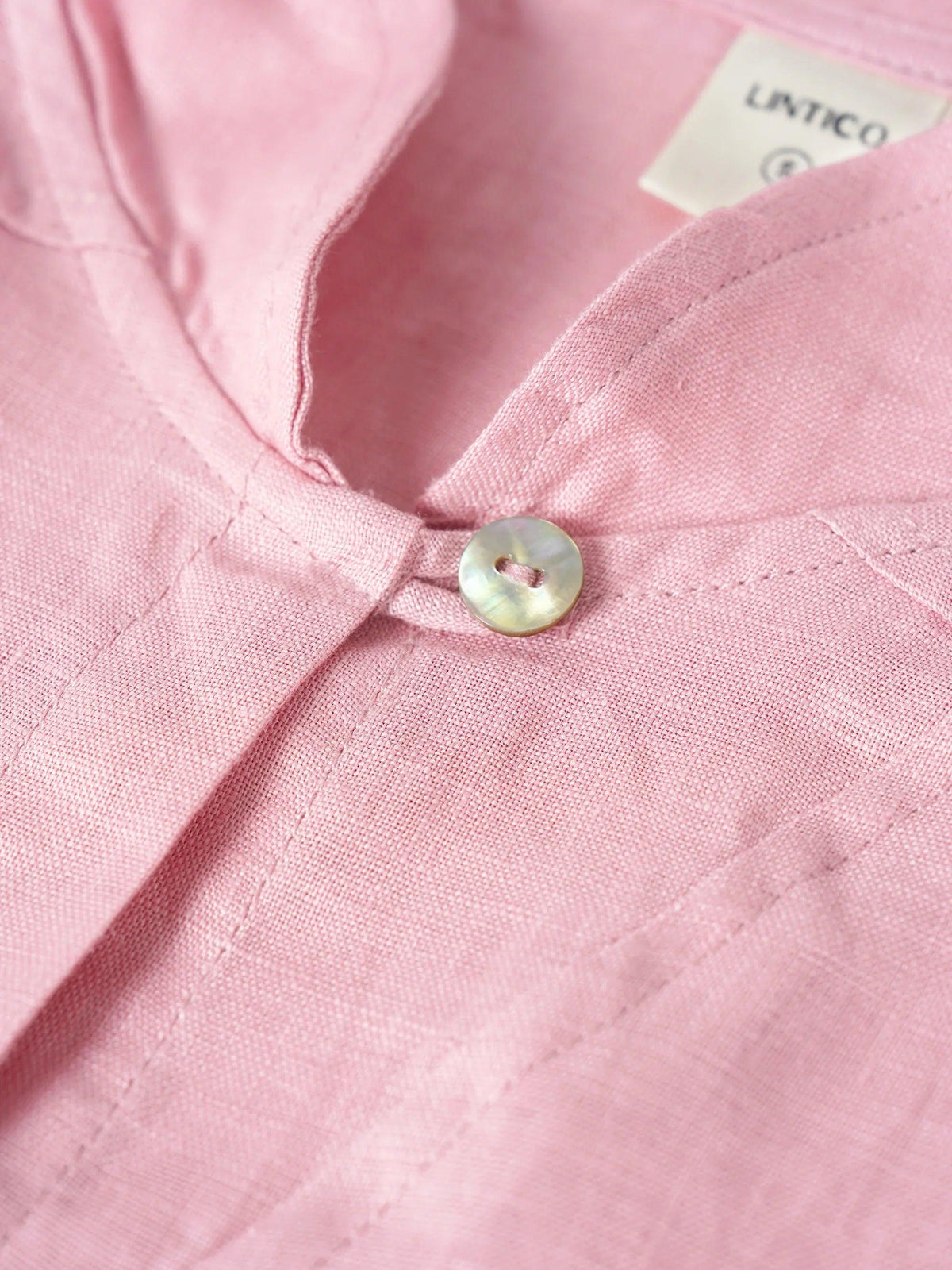 a pink shirt with a button
