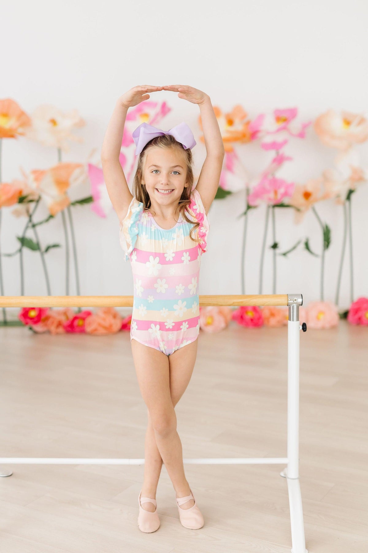 a girl standing on a ballet bar