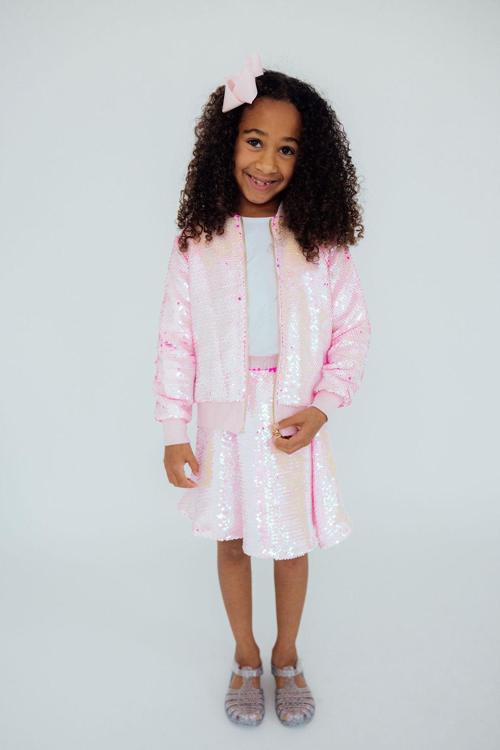a girl in a pink jacket and skirt