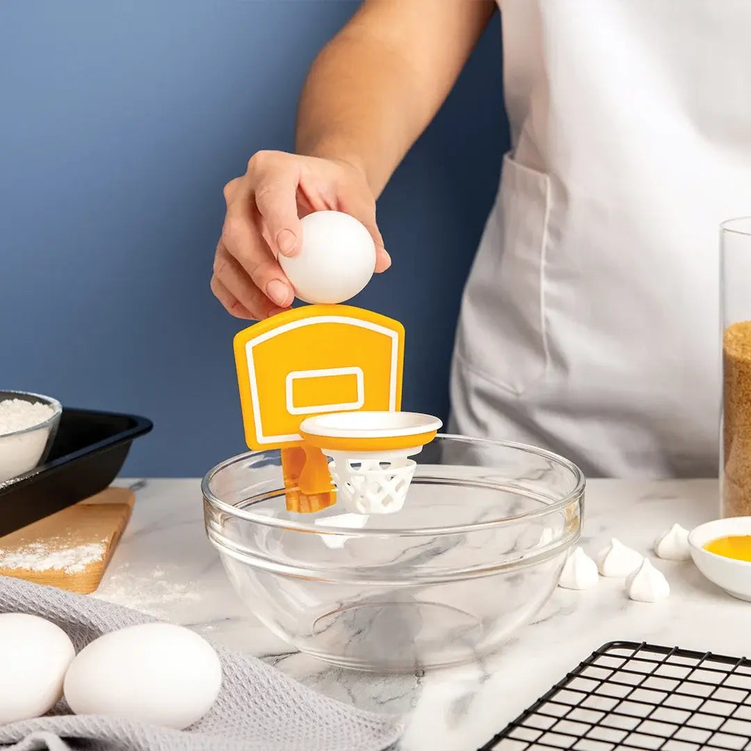 a person holding an egg into a bowl