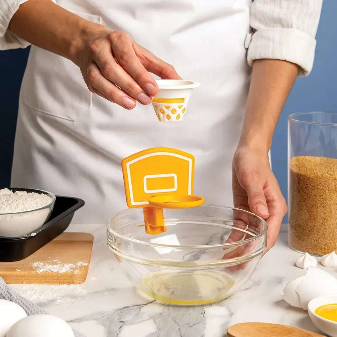 a person holding a small egg strainer over a bowl of flour