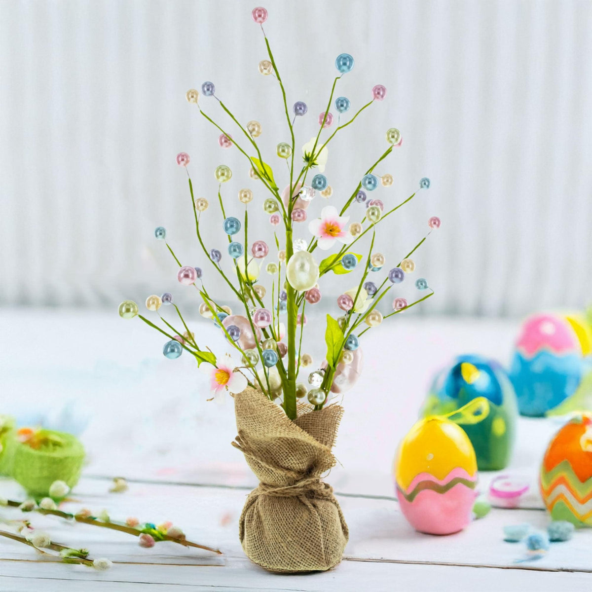 a small vase with flowers and small eggs
