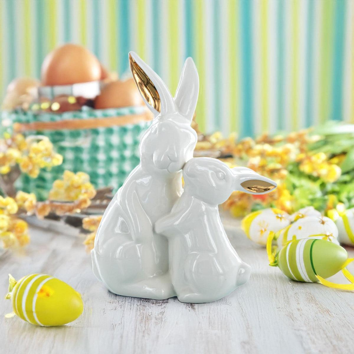 a white bunny figurine next to eggs and flowers