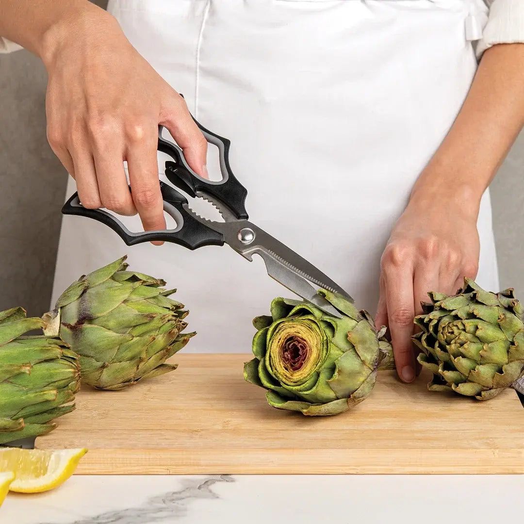 a person cutting artichokes on a cutting board