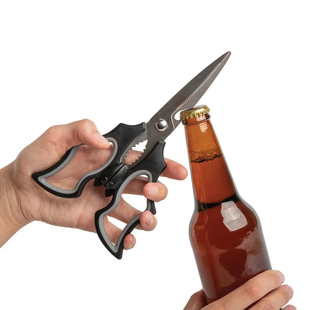a person holding a pair of scissors and a bottle of beer