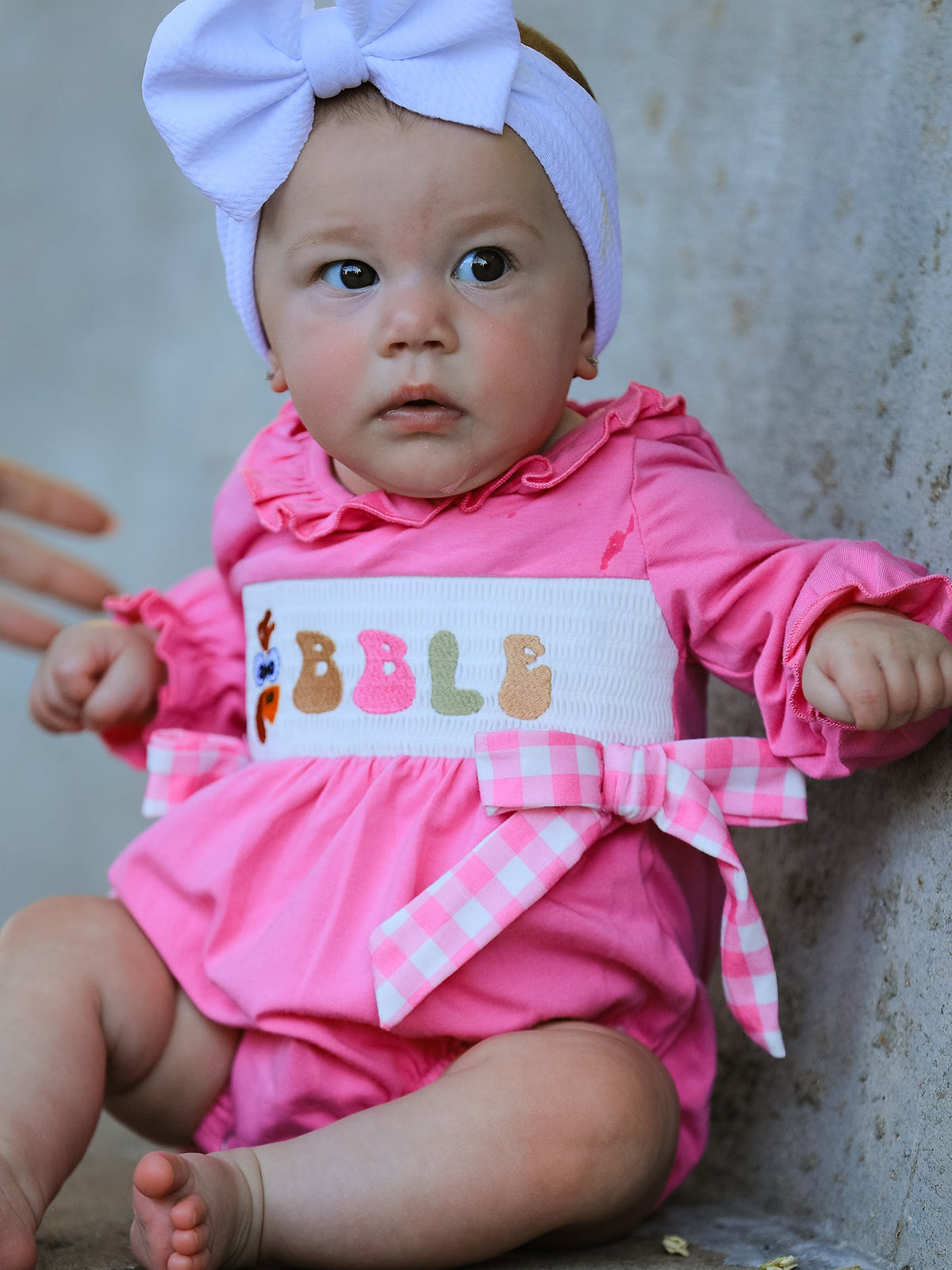 a baby in a pink outfit