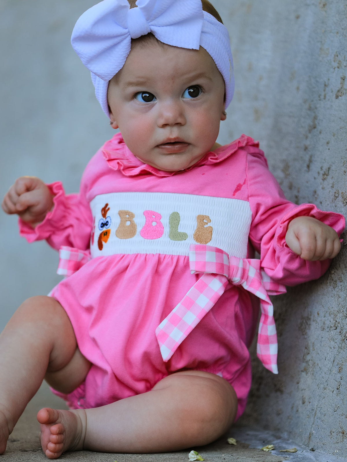 a baby in a pink outfit