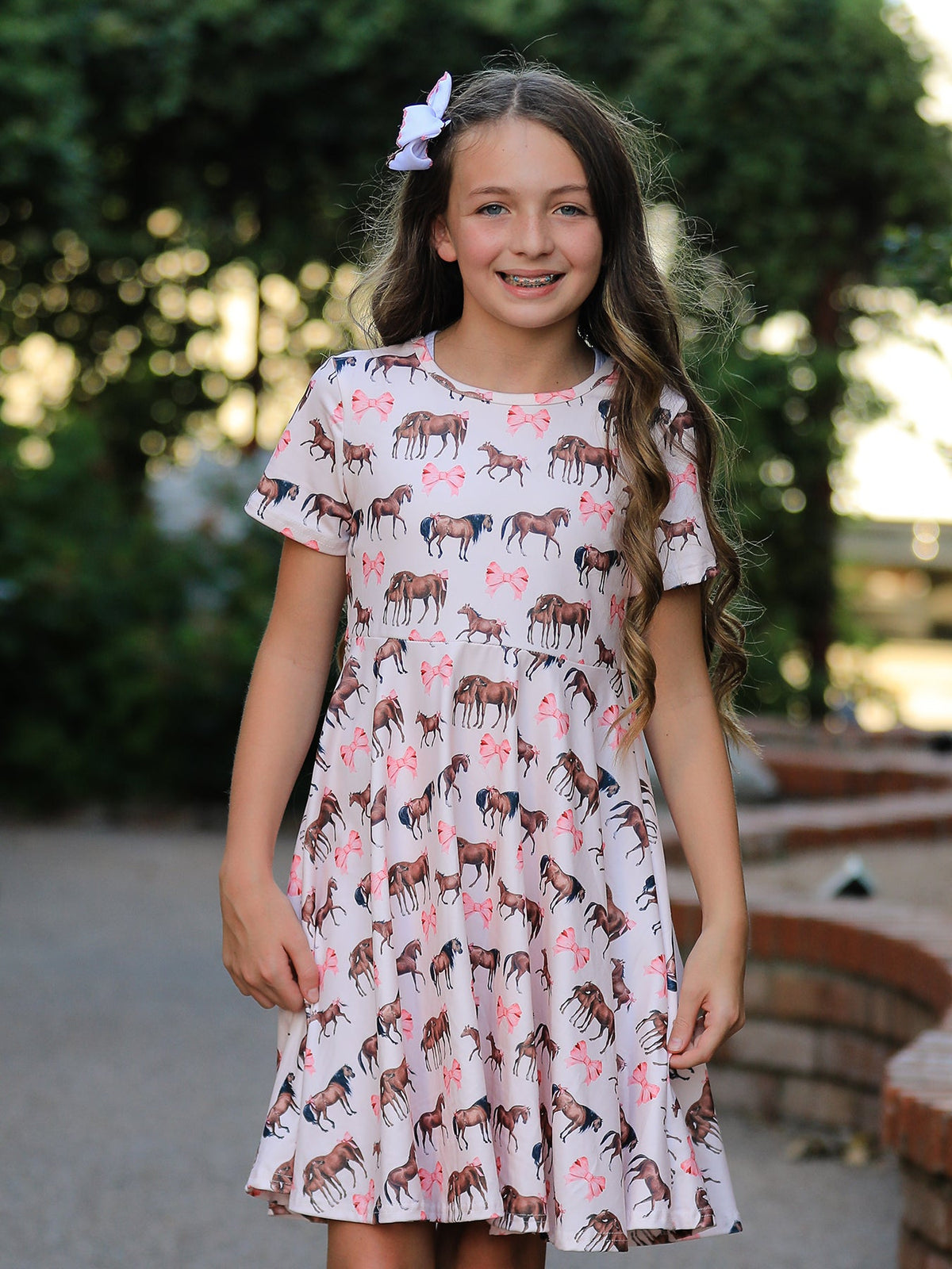 a girl wearing a dress with horses on it