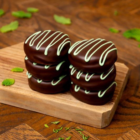 a stack of chocolate covered donuts on a wood board