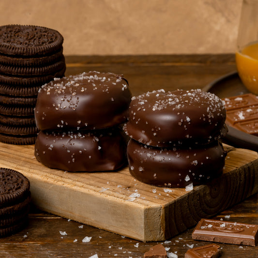 chocolate cookies and chocolate covered donuts on a wooden board