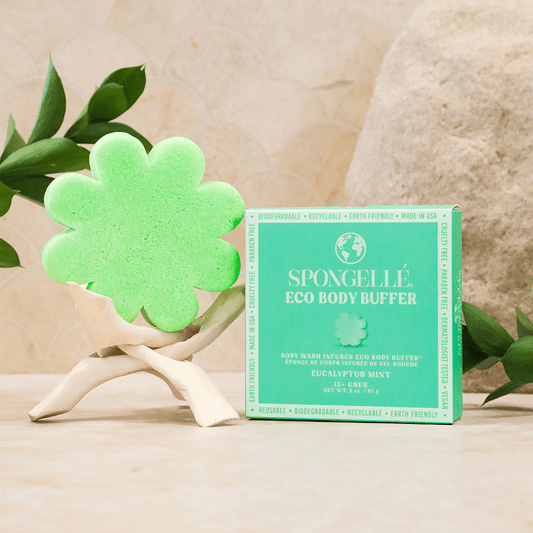 a green sponge in a box next to a box of body buffer