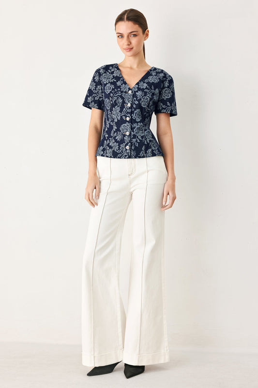 a woman in a blue shirt and white pants