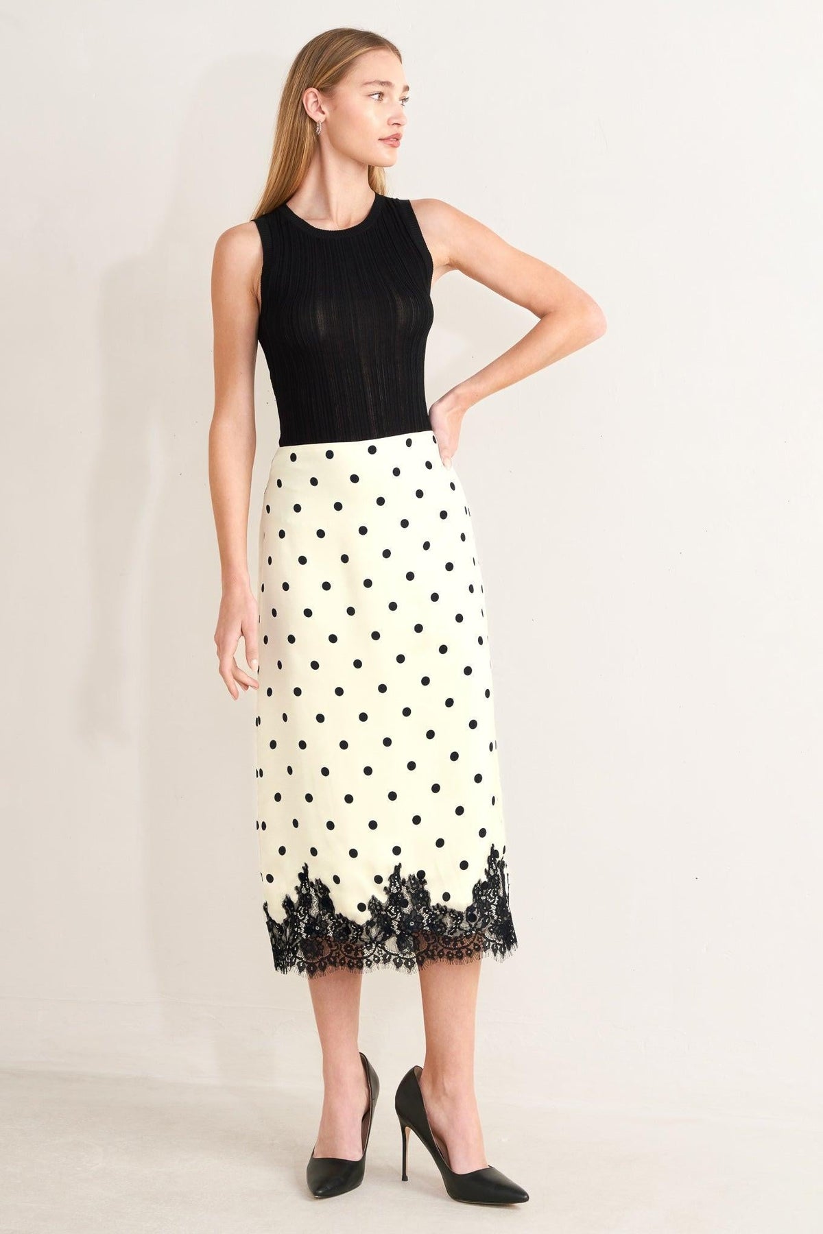 a woman in a skirt and black top