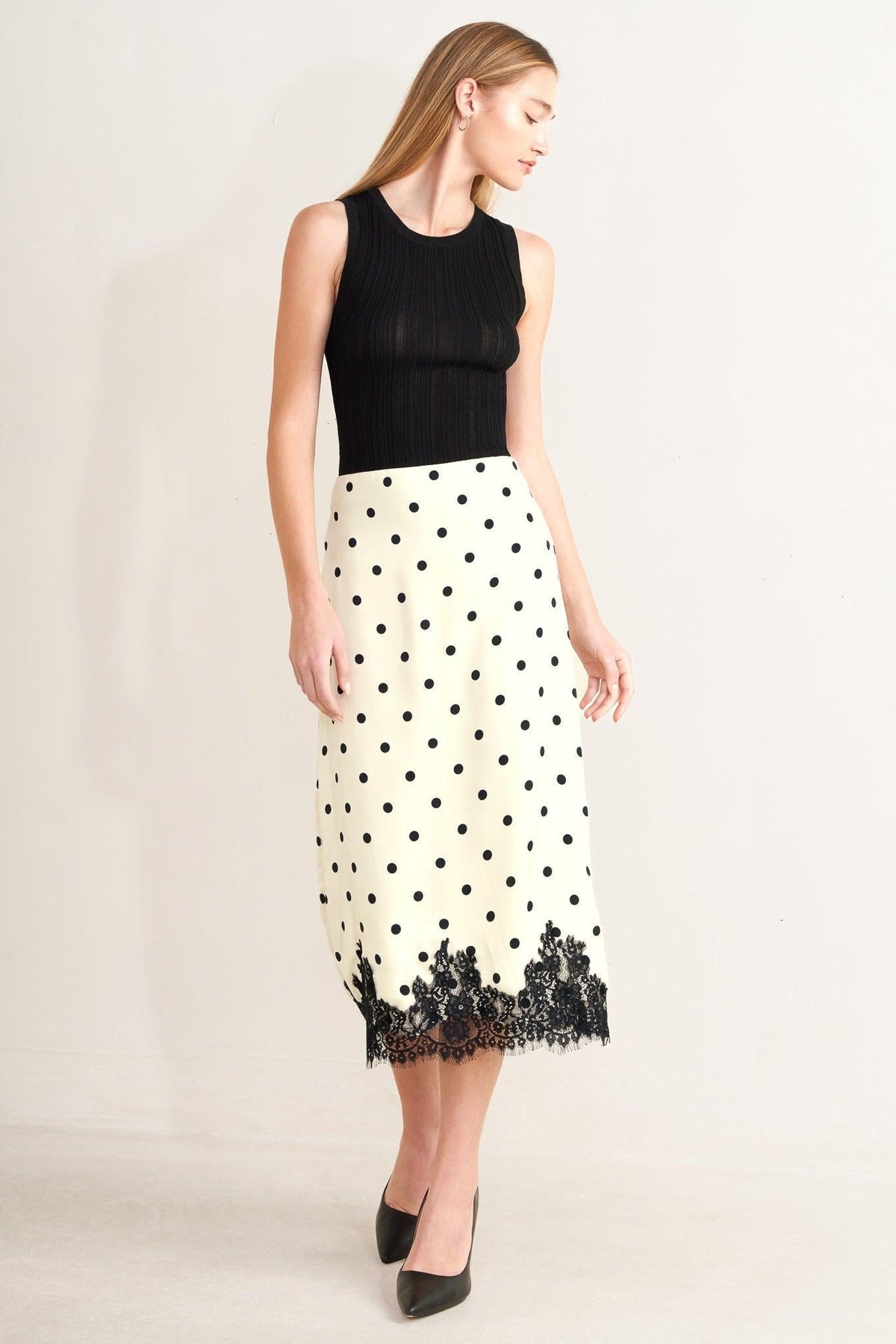 a woman in a skirt and black top