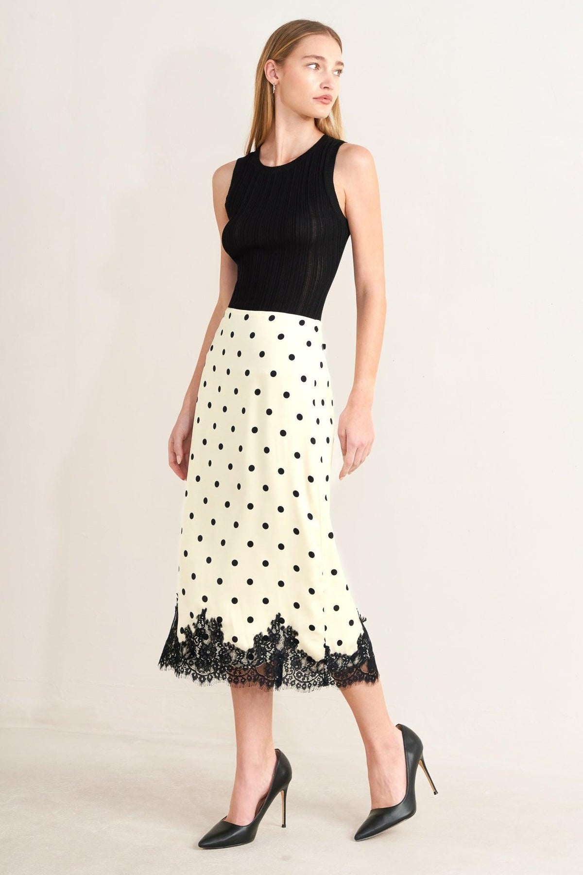 a woman in a polka dot skirt and black top