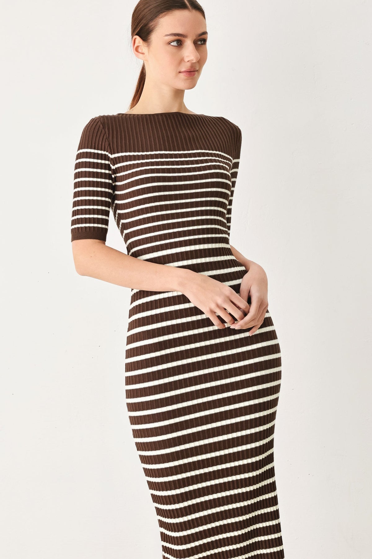 a woman in a brown and white striped dress
