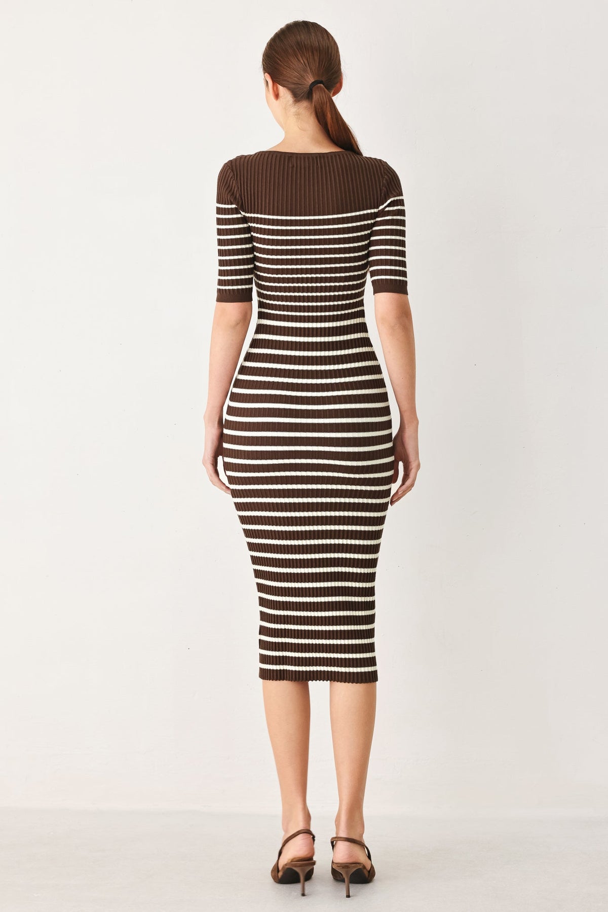 a woman in a brown and white striped dress