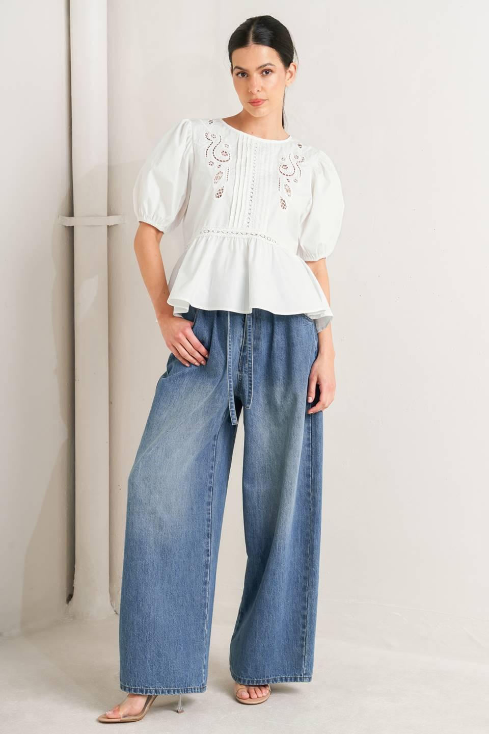 a woman in a white shirt and blue jeans