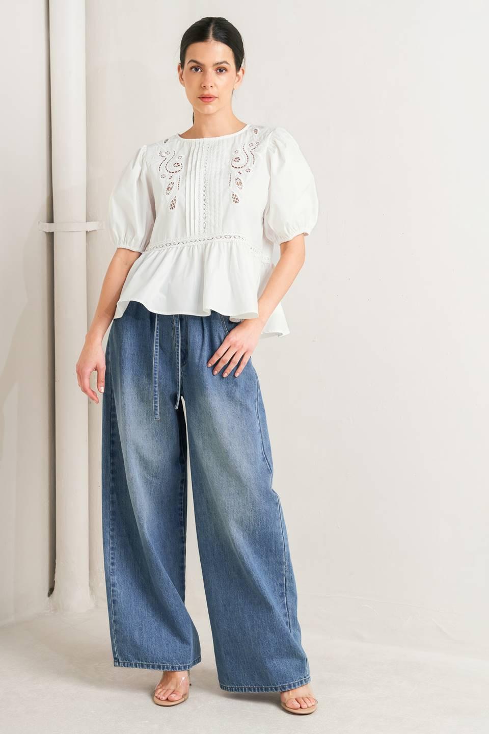 a woman in a white blouse and blue jeans