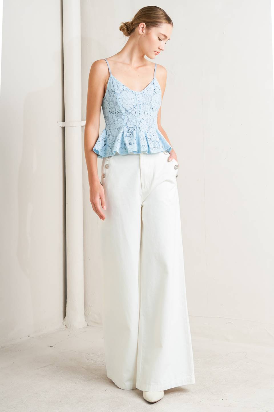 a woman in a blue top and white pants