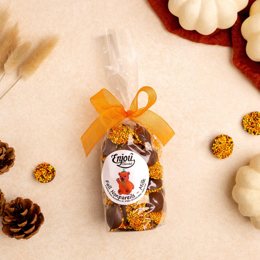 a bag of chocolates next to some small white and yellow candies