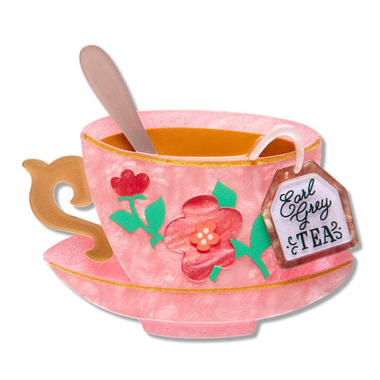 a pink tea cup with a spoon