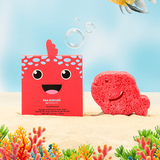 a red box with a smiling face next to a pink fish on sand