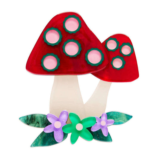 a red mushroom with green leaves and flowers