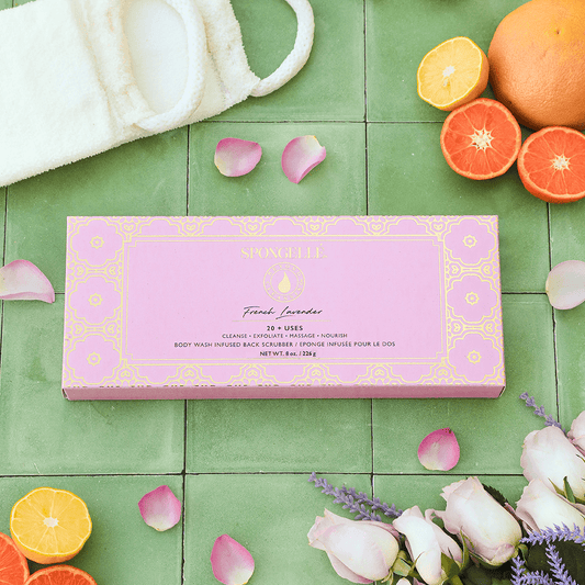 a pink box with oranges and flowers on a green tile floor