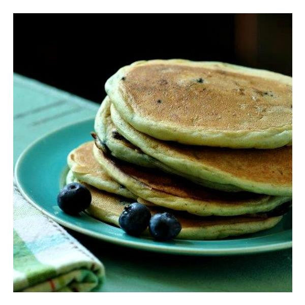 Stack of pancakes with blueberries on a teal plate