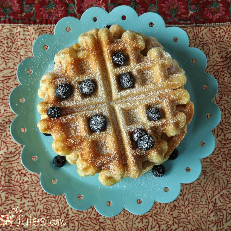 Waffle with berries on a decorative plate with a patterned background