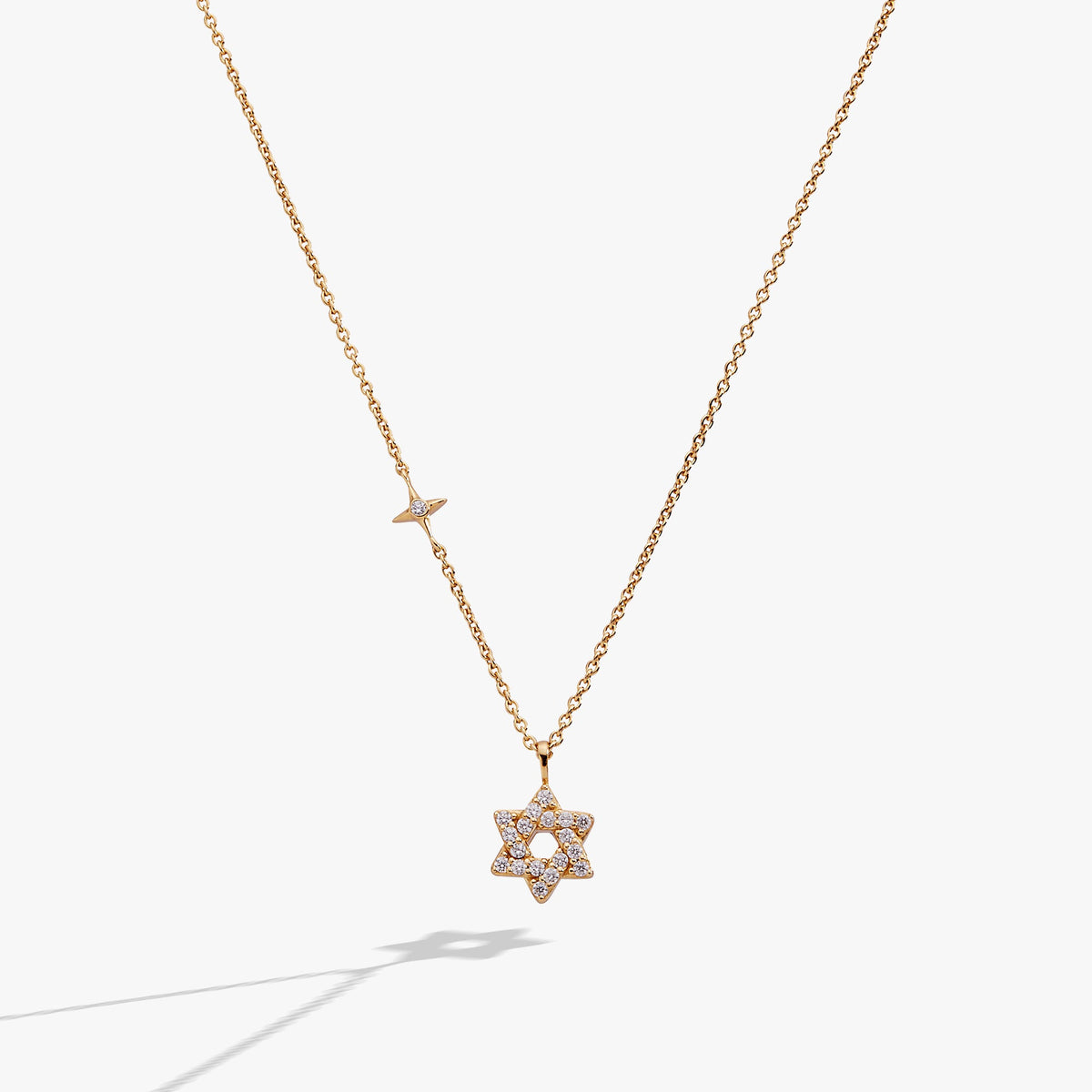 a gold necklace with a star of david pendant