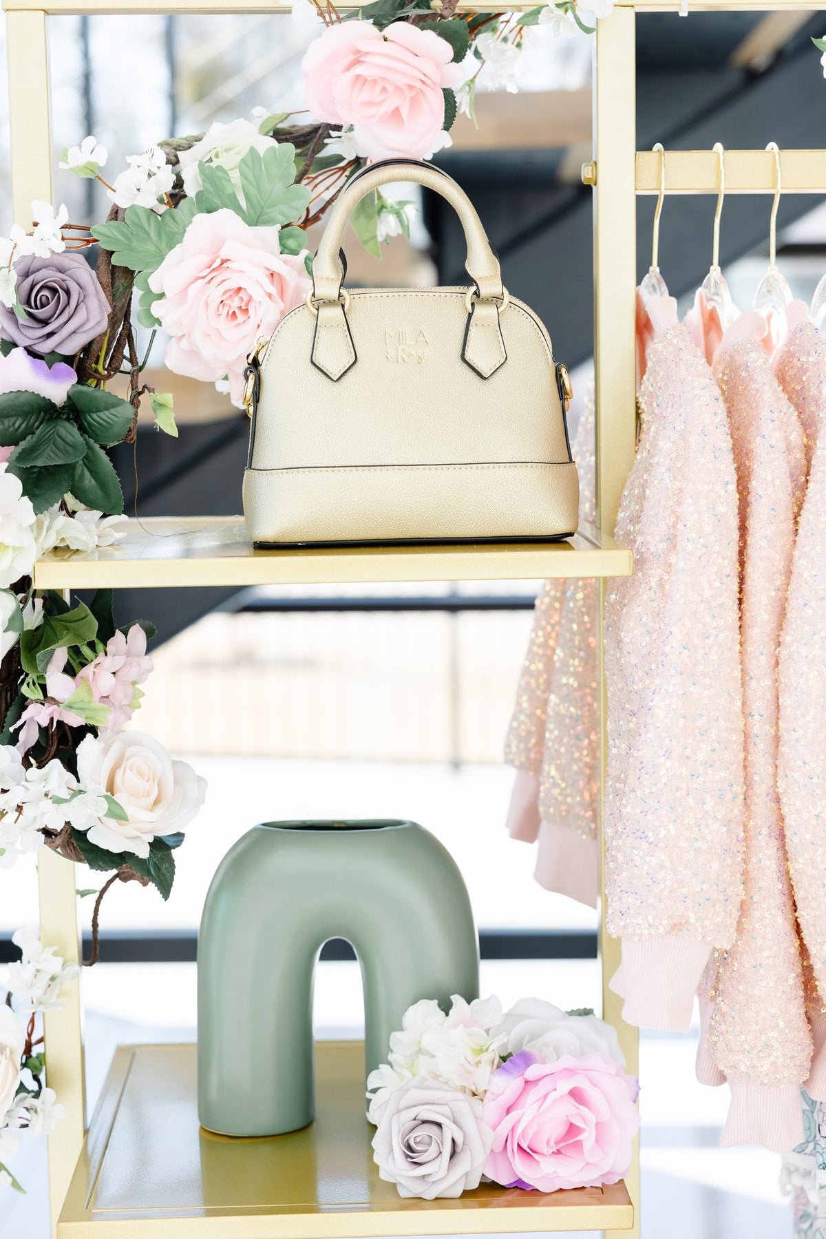 a gold purse on a shelf with swingers and flowers